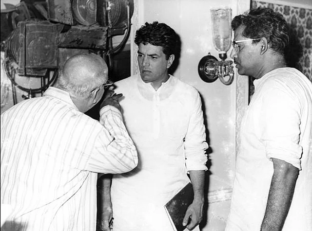 A photo from Mukherjee’s <i>Satyakam</i> shoot. Actor David Abraham (L) talks to Dharmendra (centre) as Mukherjee (R) looks on (Photo: Twitter/@jaiarjun)