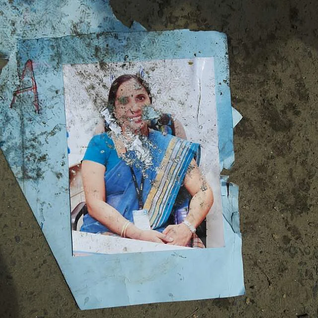 Students tear up photos of a faculty member at Amity Law School. (Photo: Amity Law School student)