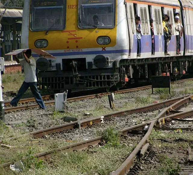 A man crossing a railway track as a Mumbai local train approaches him. (Photo courtesy: FinalMile)
