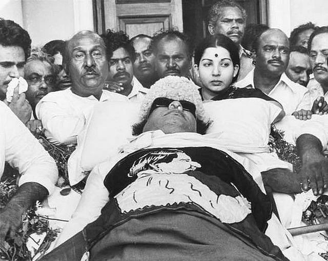 Jayalalithaa standing near MGR’s body lying in state.