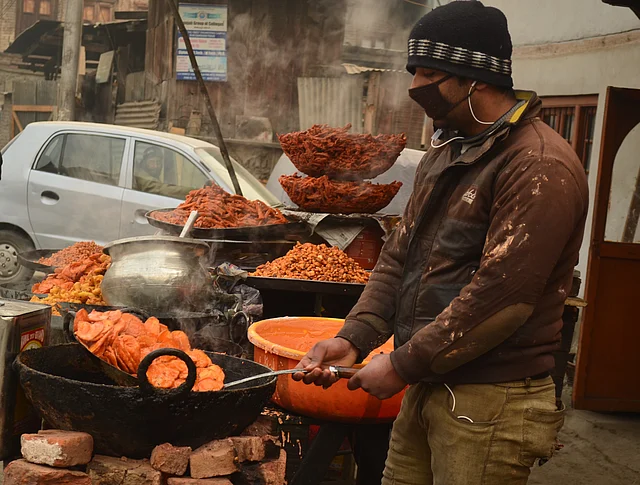 A street-food seller in downtown Srinagar fries lotus stem fries on New Year day.