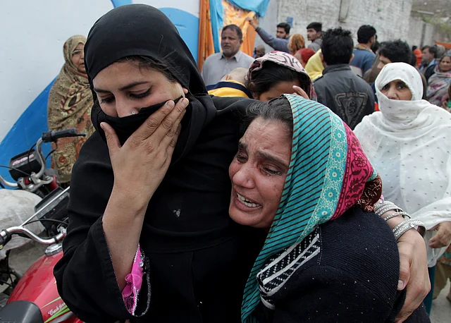 People mourn the death of a family member who was killed in the suicide blast. (Photo: AP)