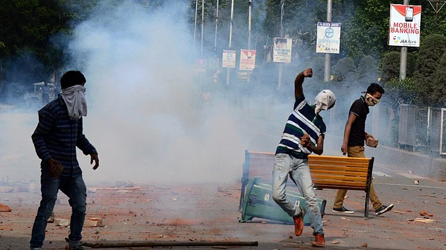 Students pelting stones during a clash with police personnel outside SP College in Srinagar, 9 May 2017. (Photo: PTI)