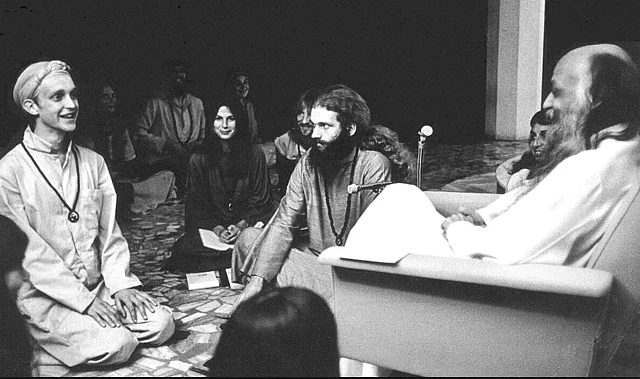 A photo of Osho with his disciples in <i>darshan</i> at Poona in 1977.