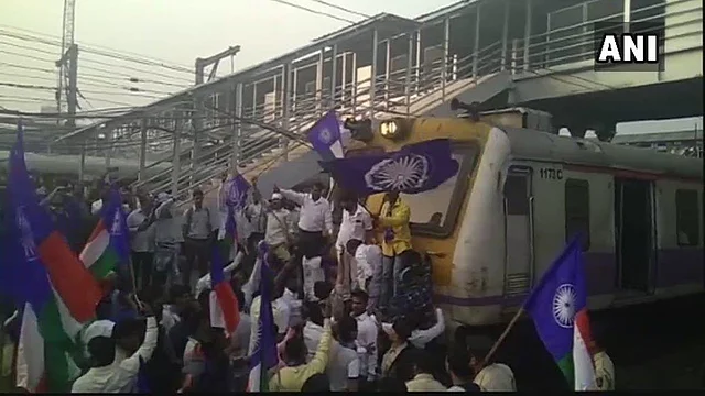 Protesters stop a train at Thane railway station.
