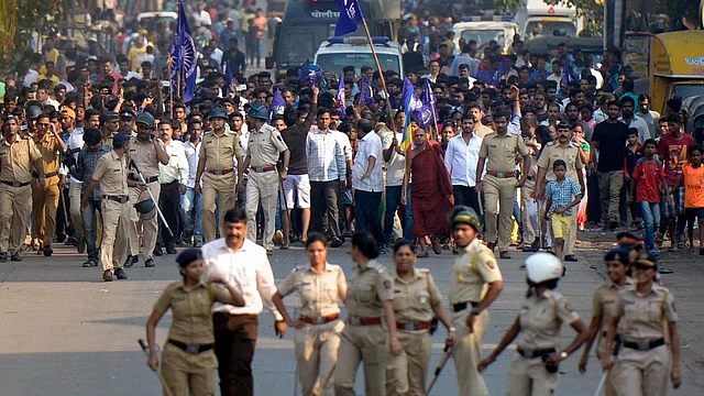 Policemen accompany protesters as they stage a demonstration in Mumbai against the violence in Pune’s Bhima Koregaon, on 2 January.