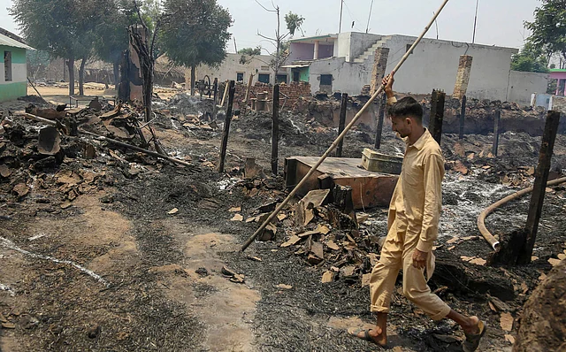 A villager walks past a damaged house after heavy shelling allegedly fired by Pakistani forces, at border village Jora Farm in R S Pura Sector, Jammu, on Tuesday.