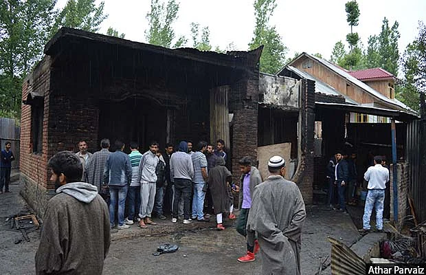 People looking at the house destroyed during an encounter in south Kashmir’s Pulwama district 