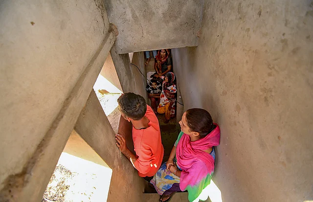 Villagers take shelter inside a community bunker during heavy shelling from the Pakistani side, along the international border.