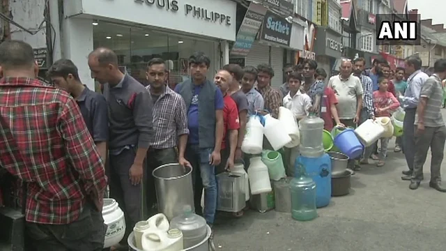 People stand in queues to fill water. 