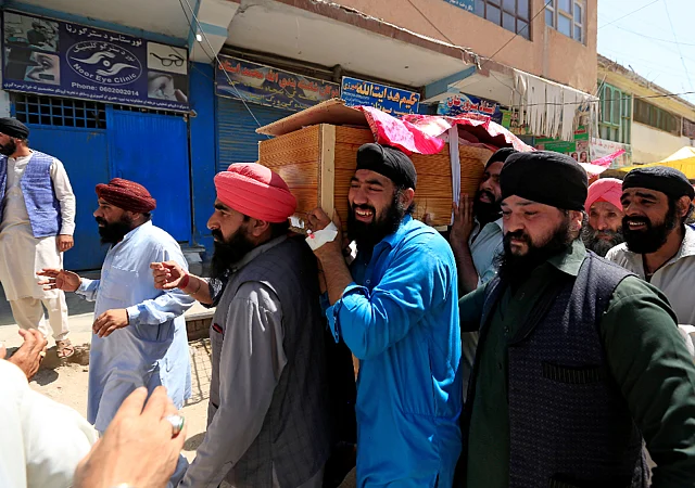 Relatives carry the dead body of the a victim of the blasts on 3 July.