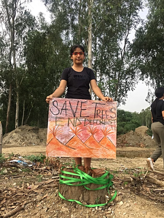 Triveni stands with a placard which she made.