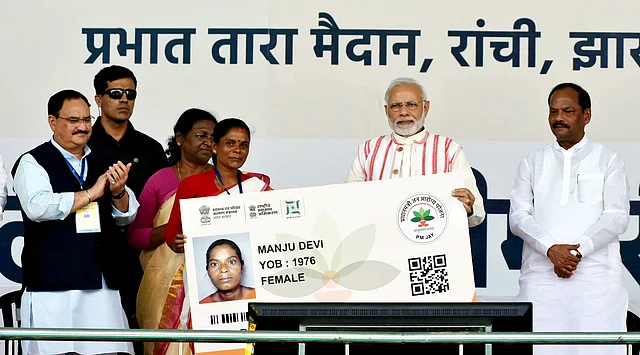 Prime Minister Narendra Modi presents a health insurance card to a beneficiary during the inauguration of “Pradhan Mantri Jan Aarogya Yojna” in Ranchi.