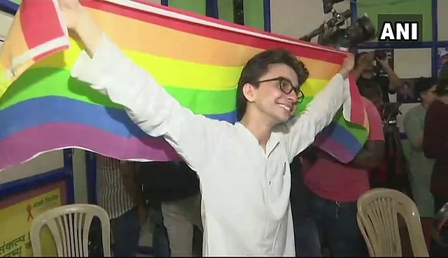 An activist in Delhi poses with the LGBTQ-flag.