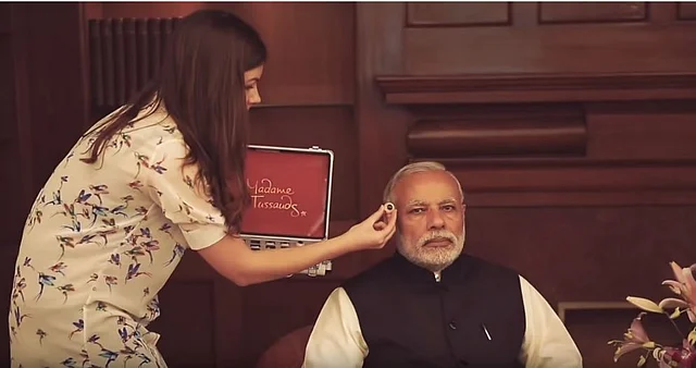 The alleged “makeup artist” is actually holding up an eyeball for a study of Modi’s face for a Madame Tussauds museum statue.