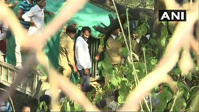 Trackers and Forest Department Personnel move the caged leopard out of the Sachivalaya.