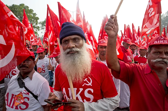 Farmers, workers and agricultural labourers wave red Communist flags as they arrive in the Indian capital for a two-day protest.