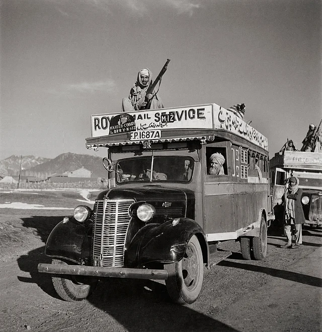A Royal Mail bus with armed guards heads out from Razmak to Jandola in Pakistan (formerly a part of India), April 1946.
