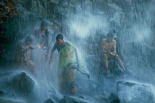 Pilgrims bathe in the Narmada’s 160-foot-tall Kadil Dhara waterfall in India, November 1988.