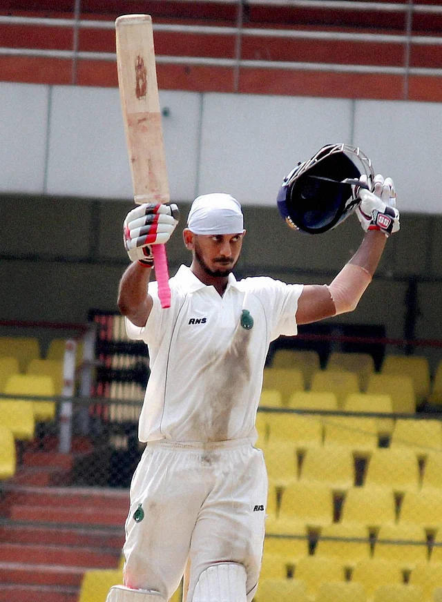Assam player Arun Karthik raises his bat after scoring century on the 3rd day of the Ranji Trophy match against Rajasthan in Guwahati on Saturday. 