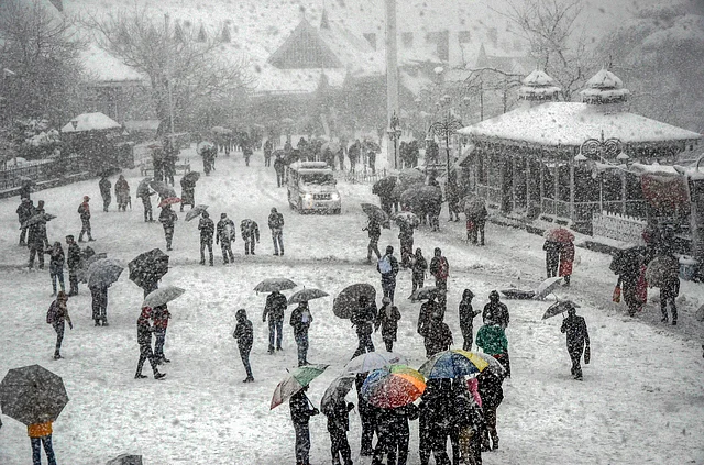 People stroll during heavy snowfall in the northern hill town of Shimla, Tuesday, 22 January 2019.