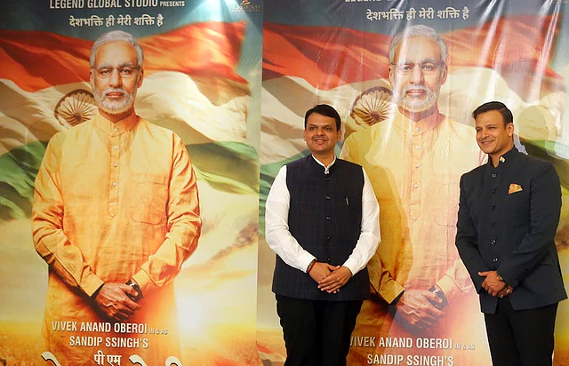 Maharashtra Chief Minister Devendra Fadnavis (left) and Bollywood actor Vivek Oberoi pose for photographs in front of posters of upcoming film <i>PM Narendra Modi</i>, a biopic on the prime minister, during its poster launch in Mumbai on Monday, 7 January, 2019. 