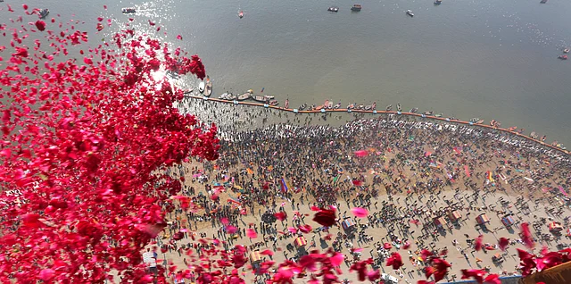 Uttar Pradesh government officials throw rose petals from a helicopter on devotees taking ritualistic dips at Sangam, on Paush Purnima during Kumbh Mela or Pitcher festival, in Allahabad on 21 January.