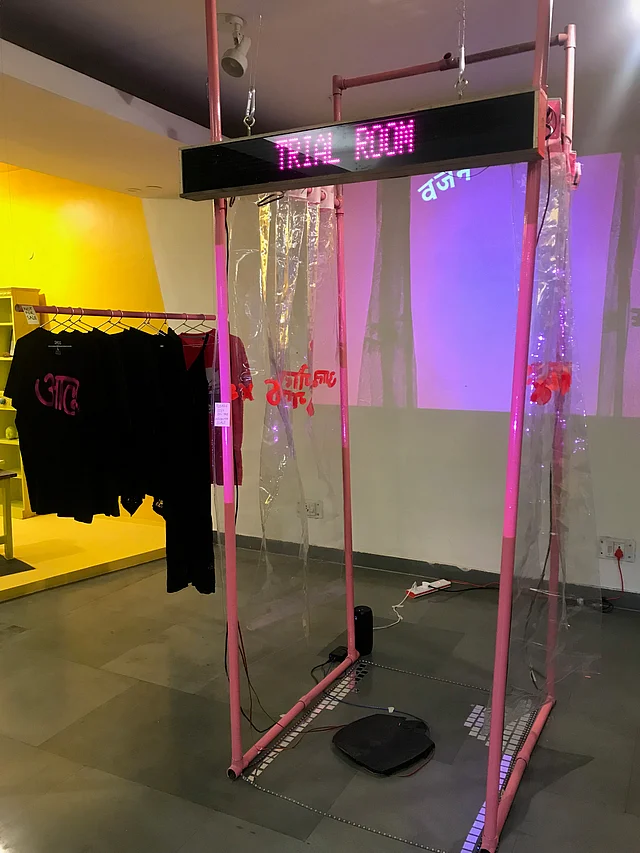 ‘The Trial Room’ by Artist Deeipikah – the shirt have <i>alu</i>, or potato, written on them, and the scene mirrors all the body shape judging that goes on inside fitting rooms 