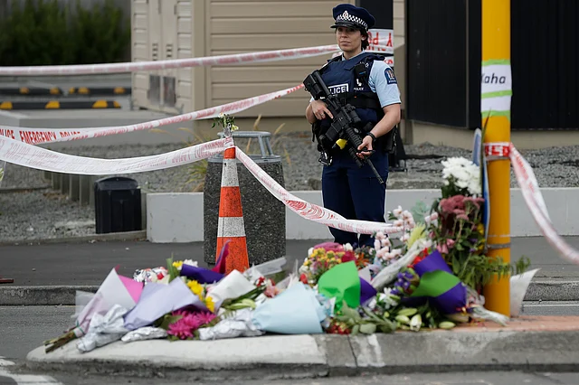 Police stand by makeshift memorial near the Linwood Mosque in Christchurch, New Zealand, Saturday, 16 March 2019, where one of the two mass shootings occurred.