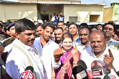 Bengaluru: Karnataka Chief Minister HD Kumaraswamy with his wife Anitha Kumaraswamy, son Nikhil Gowda show their forefinger marked with indelible ink after casting vote during the second phase of Lok Sabha polls, in Bengaluru, on April 18, 2019. (Photo: IANS)