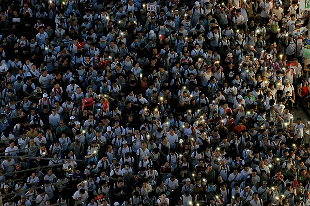 Protesters flash their smartphone lights in a downtown street during a rally against the extradition law in Hong Kong on Sunday, 9 June.