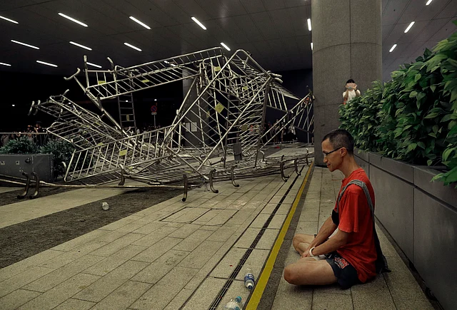 A protester sits near the barriers after the police and protesters clash against each other.