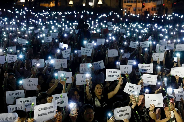 Hundreds of mothers holding placards and lit smartphones protest against the amendments to the extradition law in Hong Kong on 14 June 2019. 