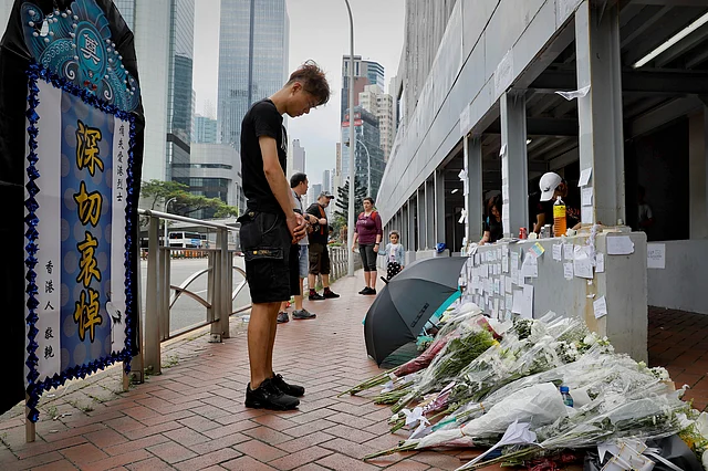 A man pays respect on the site where a man fell to his death a day earlier after hanging a protest banner against the extradition bill on the scaffolding of a shopping mall in Hong Kong, Sunday, June 16, 2019. 