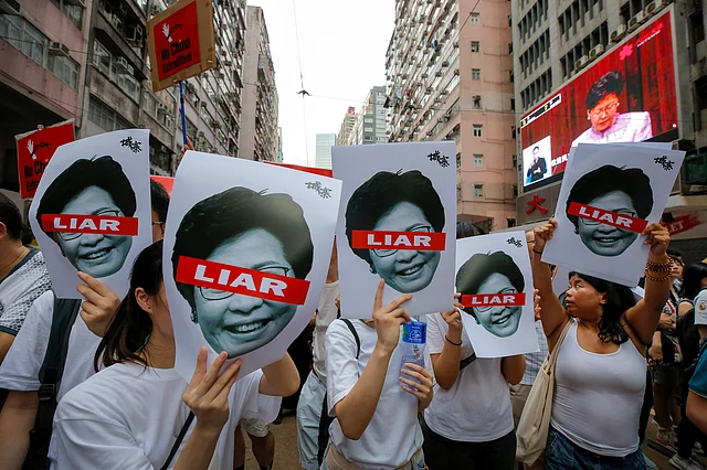 Protesters march with pictures of Chief Executive Carrie Lam.