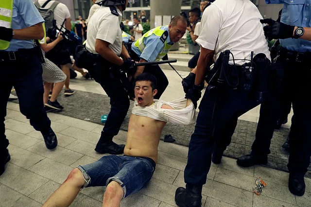 Police officers drag away a protester during a rally against the proposed amendments to the extradition law, at the Legislative Council in Hong Kong during the early hours of Monday, 10 June.