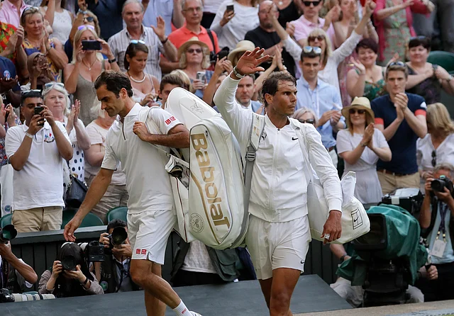 Switzerland’s Roger Federer, left, leaves the court after beating Spain’s Rafael Nadal.