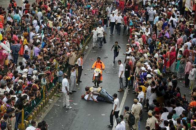 A man performs a bike stunt during the annual festival of Rath Yatra.
