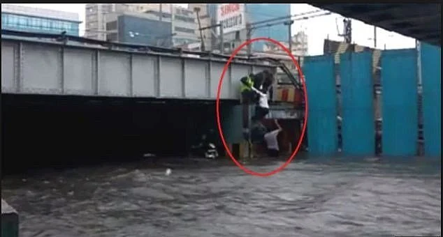 A woman being pulled out of a flooded Milan subway in Andheri.