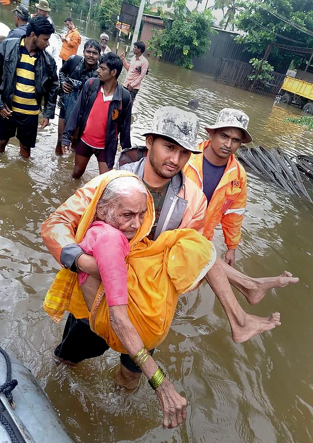 Indian Navy personnel rescue an elderly resident from a flood-hit area in the Sangli district of Maharashtra on 10 August 2019.