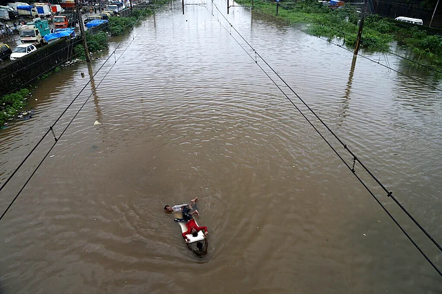 In this 4 August 2019 photo, youths play at a flooded train track following heavy monsoon rains in Mumbai.