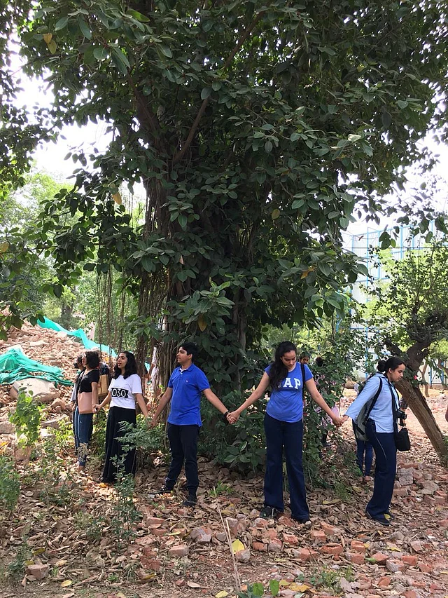 School children form a circle around a “Pilkhan’’ tree in New Delhi. They had saved it from being felled in a demolition drive last year.