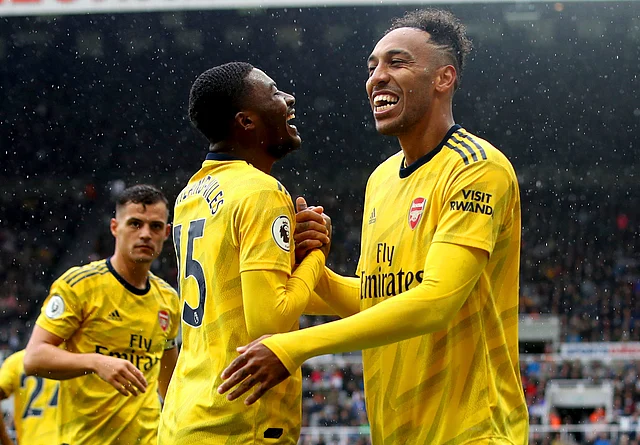 Arsenal’s Pierre-Emerick Aubameyang, right, celebrates scoring his side’s first goal of the game with teammate Ainsley Maitland-Niles during the English Premier League soccer match.