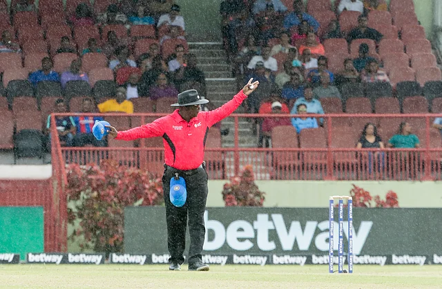 India bowler Mohammed Shami, left, watches to the outfield as West Indies opening batsmen Chris Gayle, center, and Evin Lewis, right run between the wickets during their first One-Day International cricket match in Providence, Guyana.
