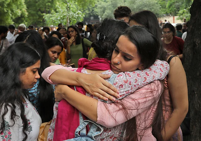 A Kashmiri woman consoles another who broke down as Kashmiris living in New Delhi gather for a function to observe Eid al-Adha away from their homes.