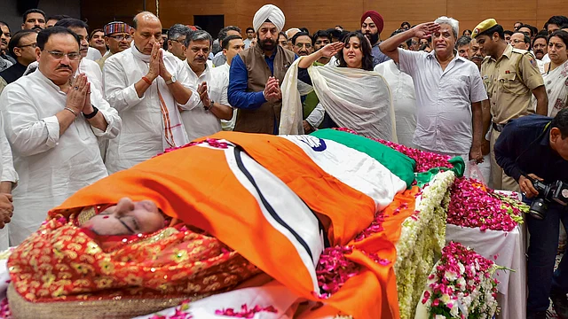 Bansuri Swaraj, daughter, and Swaraj Kashal, husband, of former External Affairs Minister Sushma Swaraj, pay tribute to the mortal remains of the latter before they were taken for her last rites, in New Delhi on Wednesday, 7 August.