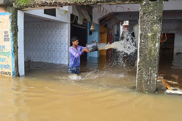 A man attempts to drain floodwater from temple following heavy monsoon rain, in Jabalpur on 10 August 2019.