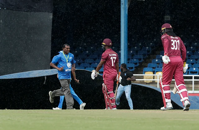 West Indie openers Evin Lewis and Chris Gayle leave the ground after rain stopped play during their third ODI against India.