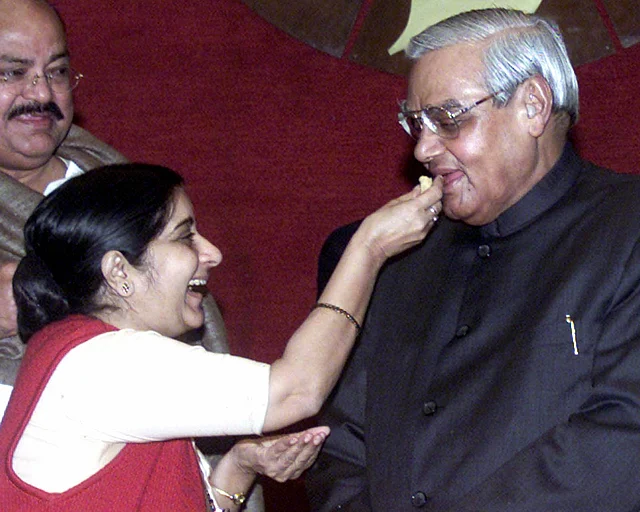 Then-PM Vajpayee being fed sweets by Sushma Swaraj, a member of his cabinet, during a BJP parliamentary party meeting in New Delhi on 23 December 2003.