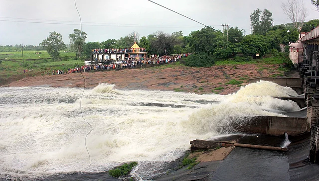 Water gushes out as people witness the opening of two sluice gates of Bhad Bhada Dam after the water level of Upper Lake touched full tank capacity following incessant rains in Bhopal on 10 August 2019. 